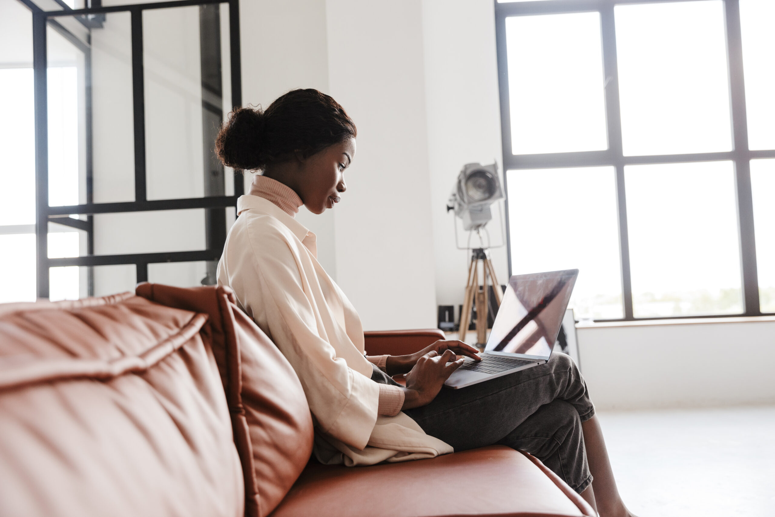 African concentrated woman working with laptop computer